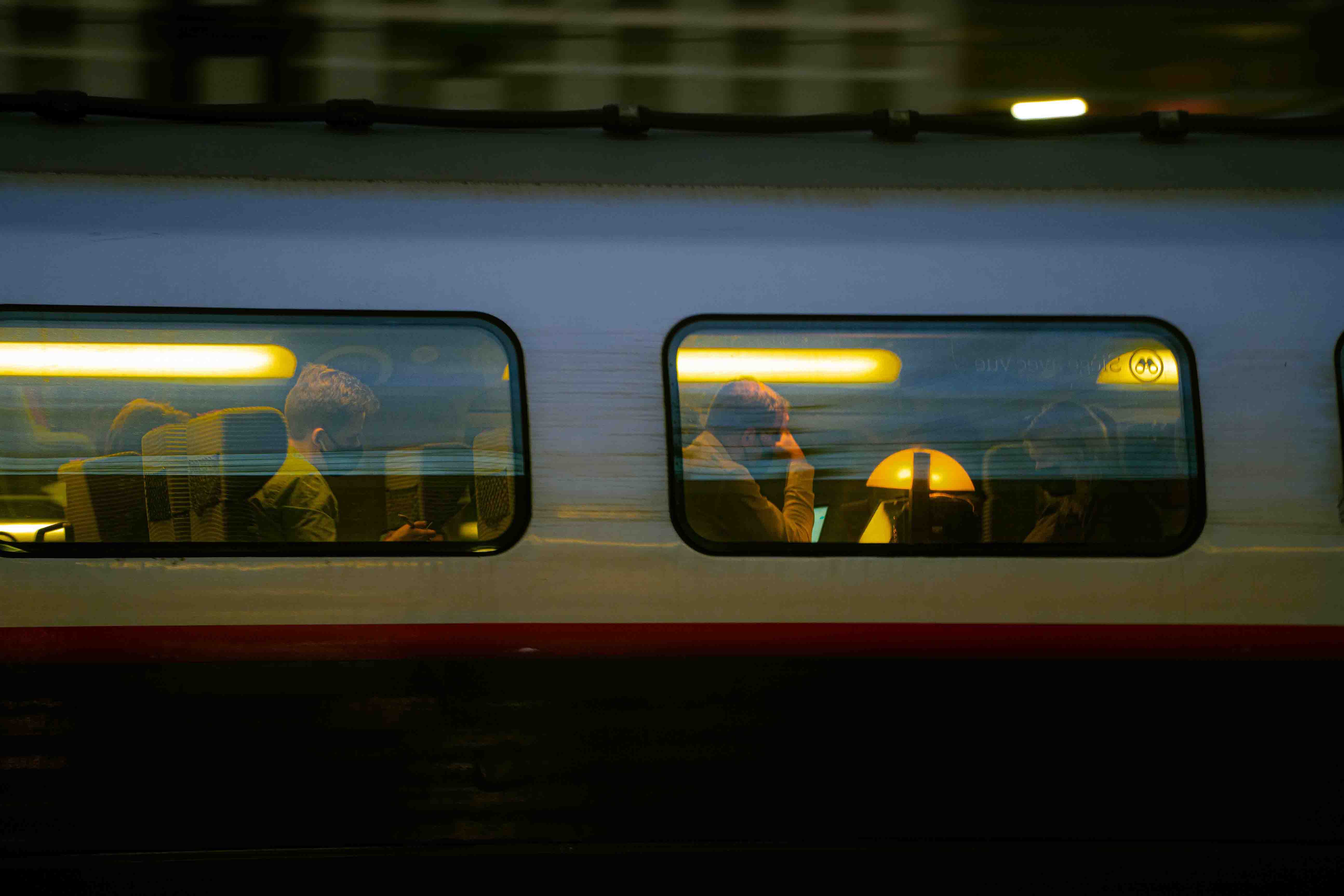Voyageurs visibles à travers les fenêtres d'un train à Lille
